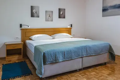 a bedroom with a large bed with a blue blanket at Domačija Log v Bohinju in Bohinjska Bistrica