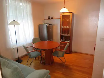 a living room with a table and chairs and a refrigerator at Peony in Rogaška Slatina