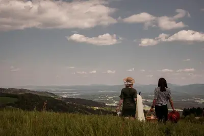 two women standing on a hill looking at a valley at Brunarica Macesen Smogavc in Zreče