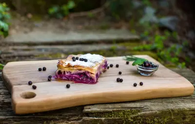 a piece of food sitting on a wooden cutting board at Brunarica Macesen Smogavc in Zreče