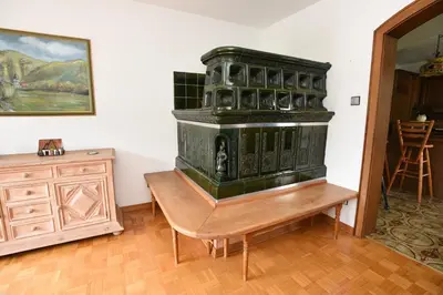 a green stove sitting on a wooden table in a room at LakeView Apartment in Preddvor