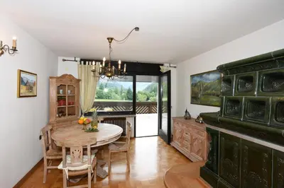 a dining room with a table and a kitchen at LakeView Apartment in Preddvor