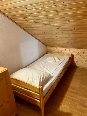 a bed in a room with a wooden ceiling at Cosy country home, Lendava in Lendava