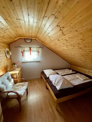 a room with two beds and a chair in it at Cosy country home, Lendava in Lendava
