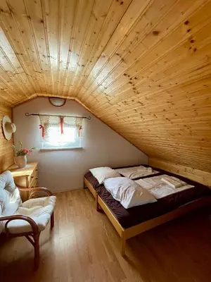 a bed in a room with a wooden ceiling at Cosy country home, Lendava in Lendava