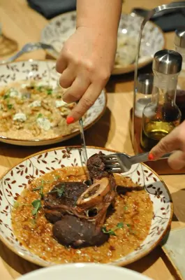 a person eating a plate of food on a table at Vila De Casa in Ribnica