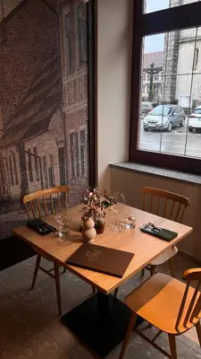 a wooden table in a room with chairs and a window at Vila De Casa in Ribnica