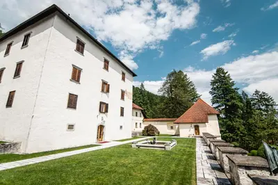 a large white building with a grass yard at Grad Strmol in Cerklje na Gorenjskem