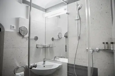 a bathroom with a sink and a glass shower at Grad Strmol in Cerklje na Gorenjskem