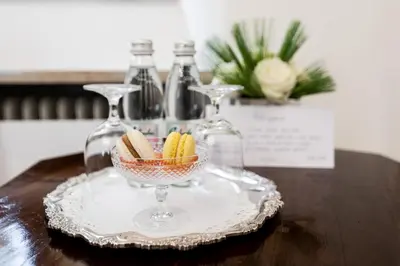 a glass plate with a bowl of snacks on a table at Grad Strmol in Cerklje na Gorenjskem