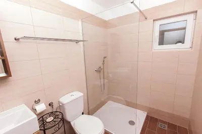 a bathroom with a toilet and a glass shower at Effie Perine Apartments in Bled