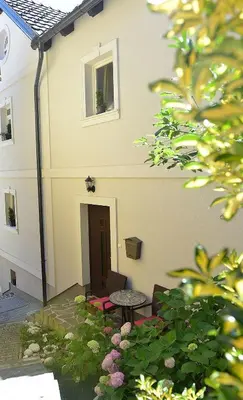 a patio with a table and chairs in front of a building at Effie Perine Apartments in Bled