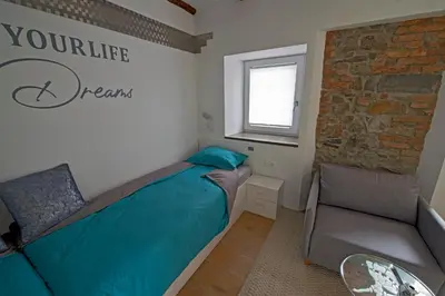 a bedroom with a bed and a couch and a window at Caissa - an old country lady in a new modern dress in Deskle