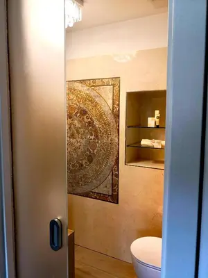 a bathroom with a toilet and a rug on the wall at Caissa - an old country lady in a new modern dress in Deskle