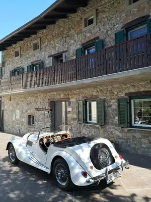 a white car parked in front of a building at Caissa - an old country lady in a new modern dress in Deskle