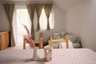 a room with a table with vases and a couch at Apartments pr' Špeli in Bohinj