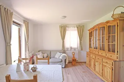 a living room with a couch and a large wooden cabinet at Apartments pr' Špeli in Bohinj