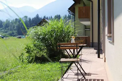a table and two chairs sitting on a porch at Apartments pr' Špeli in Bohinj