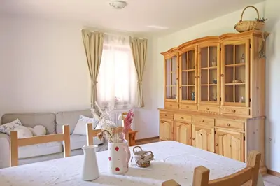 a living room with a table and a wooden cabinet at Apartments pr' Špeli in Bohinj