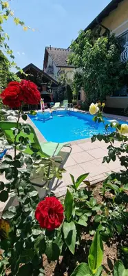 a swimming pool with red roses in front of it at APARTMAN MURKO P-3 in Brest