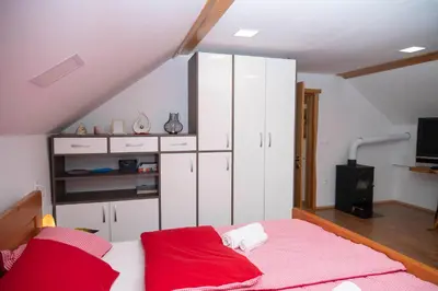 a bedroom with white cabinets and a bed with red sheets at Apartma ''Pri Movernu'' in Semič