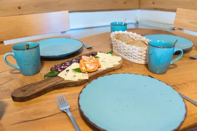 a wooden table with blue plates and utensils on it at Apartma ''Pri Movernu'' in Semič