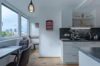 a kitchen with white cabinets and a table and a window at TAMLiving Ljubljana 2BR Center 3 Bridges Great View Kitchen in Ljubljana