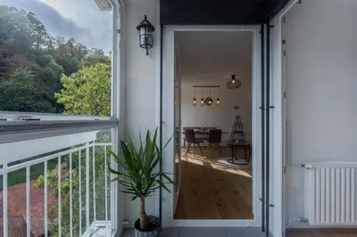 an open door leading to a balcony with a table at TAMLiving Ljubljana 2BR Center 3 Bridges Great View Kitchen in Ljubljana