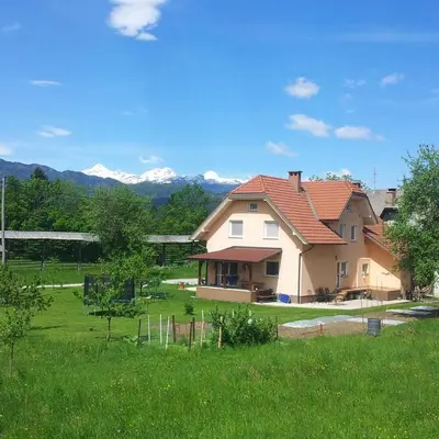 a house with a red roof on a green field at Valant Apartment ID I00070 in Bled