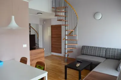 a living room with a couch and a spiral staircase at Apartments Sofija in Bled