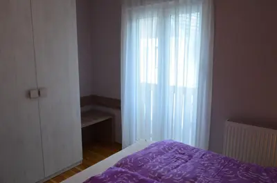 a bedroom with a purple bed and a window at Apartments Sofija in Bled