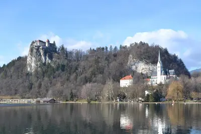 a castle sitting on top of a mountain next to a lake at Apartments Sofija in Bled