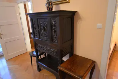 a dark wooden cabinet and a stool in a room at Villa Elasan in Bled