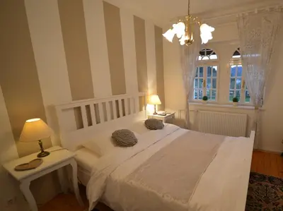 a bedroom with a white bed and a chandelier at Villa Elasan in Bled