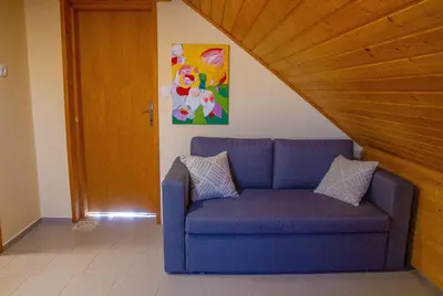 a blue couch with two pillows sitting in a room at Andy's Holiday Home with HotTub & Sauna in Podbočje
