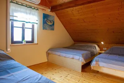 a bedroom with two beds in a wooden cabin at Andy's Holiday Home with HotTub & Sauna in Podbočje
