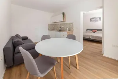 a living room with a table and chairs and a couch at Apartments Berni in Ljubljana