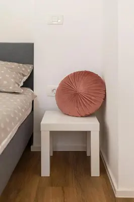 a pillow sitting on a table next to a bed at Apartments Berni in Ljubljana