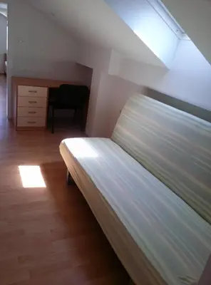 a large bed in a room with a desk at Bed and Breakfast Špelca in Pivka
