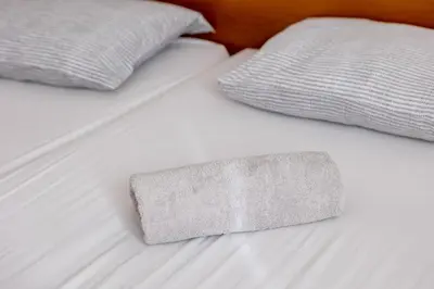 a white bed with two pillows and a sock on it at Bed and Breakfast Špelca in Pivka