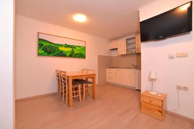 a living room with a table and a kitchen at Guesthouse Les in Brežice