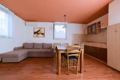 a kitchen and living room with a table and a couch at Guesthouse Les in Brežice