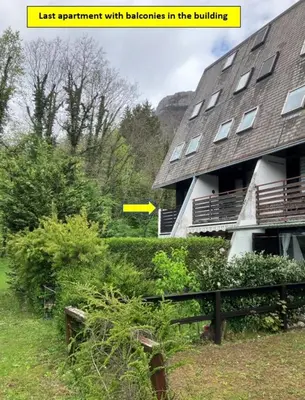 a building with a yellow sign in front of it at Apartma Manfreda Bovec in Bovec