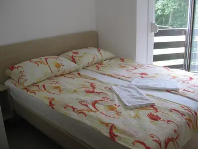 a bed with a blanket and two towels on it at Apartma Manfreda Bovec in Bovec