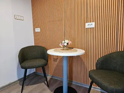 a table with two chairs and a vase of flowers on it at Central Ljubljana Apartment , 150m from Prešeren Square in Ljubljana