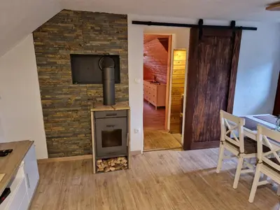 a living room with a brick wall with a stove at koča na pikovem in Črna na Koroškem