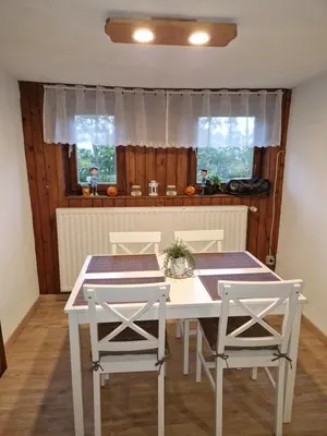 a dining room with a table and two chairs at koča na pikovem in Črna na Koroškem