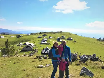 a family standing on top of a hill with tents at Farmhouse Štiftar in Solčava