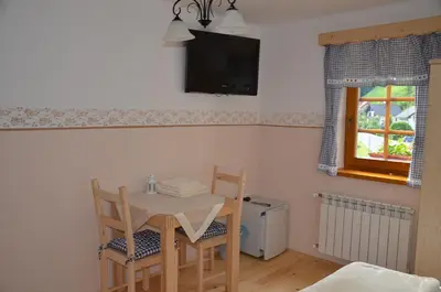 a dining room table with two chairs and a television at Farmhouse Štiftar in Solčava