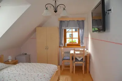 a bedroom with a bed and a table and a window at Farmhouse Štiftar in Solčava